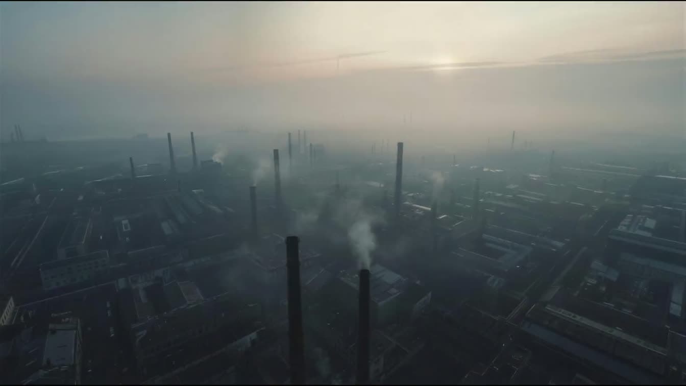 Calm, hazy aerial view of a Nordic/European industrial skyline at dawn — steel-production infrastructure and mineral-processing atmosphere. Not footage of an operating LithoBind facility.